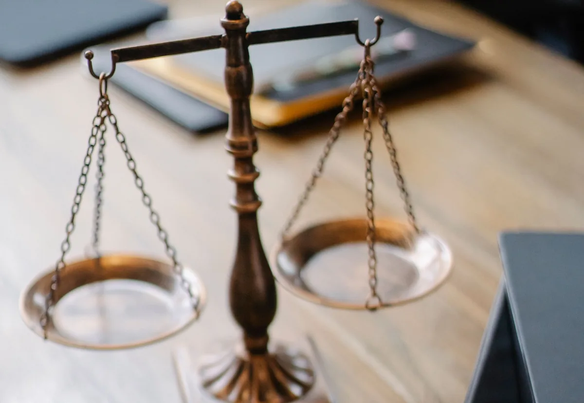 Balanza de la justicia y mazo sobre una mesa de despacho