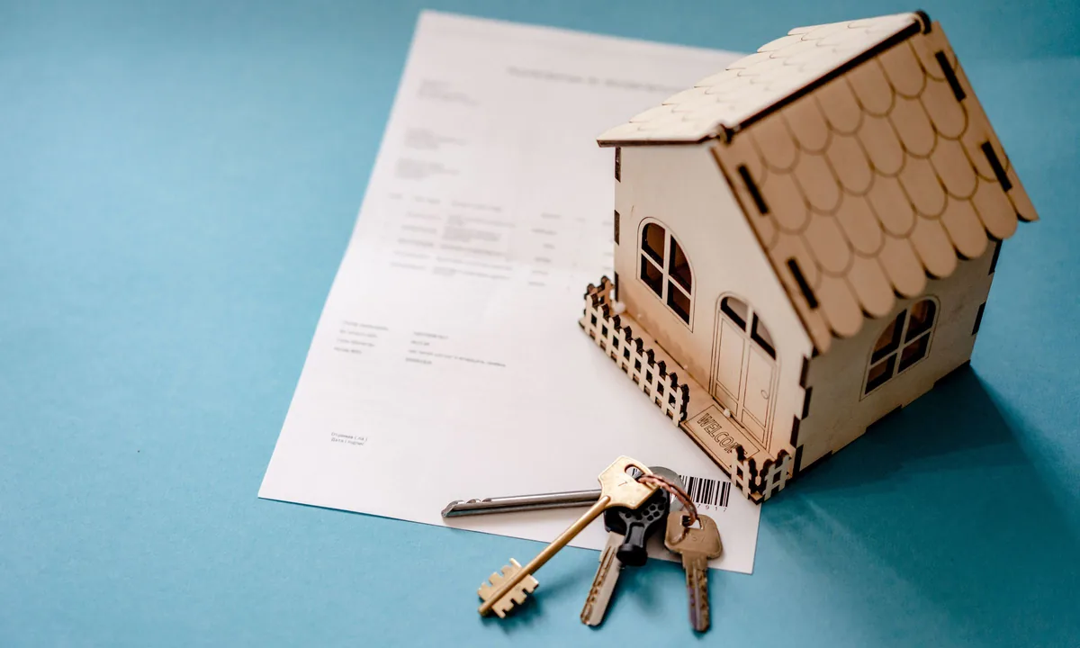 Casa en miniatura, llaves y contrato sobre una mesa: la herencia de una vivienda